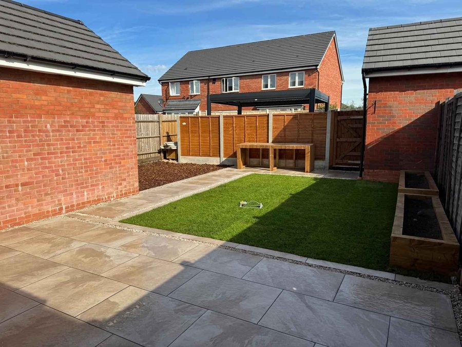 Landscaped rear garden with porcelain patio, lawn, pergola and sleeper planters by DOT Services