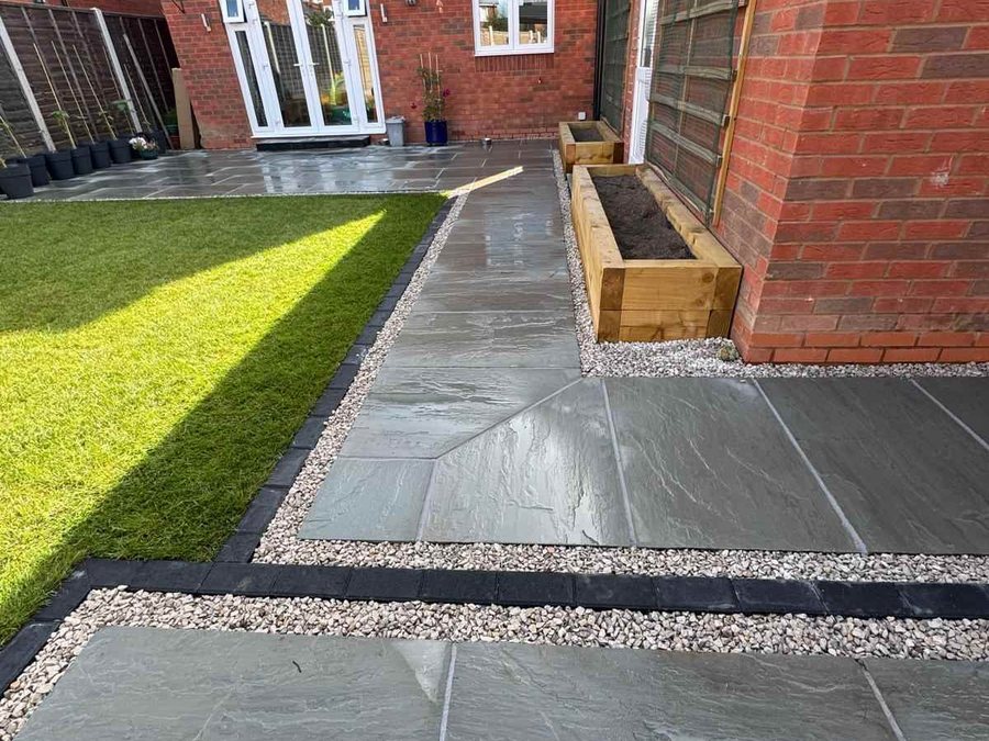 Indian sandstone patio and path with charcoal edging and sleeper planters