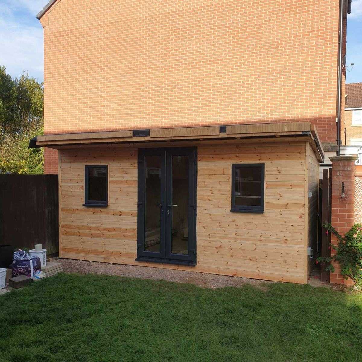 Timber-clad garden building with anthracite French doors and windows, built by DOT Services