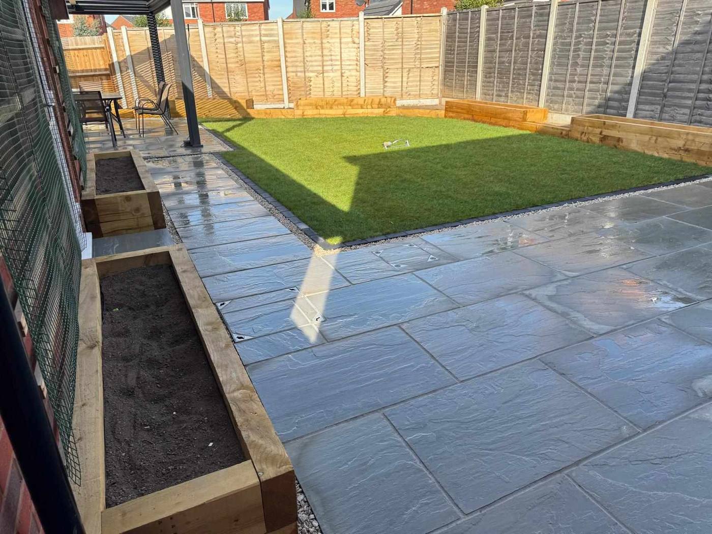 Grey sandstone path and patio alongside raised timber sleeper planters in Meir, Stoke-on-Trent