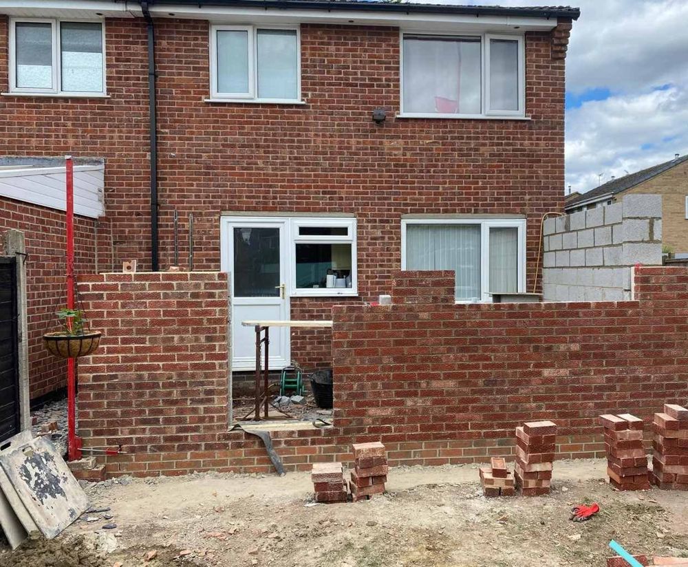The back of the house in Sinfin, Derby during the build, with the new brick walls going up and props holding the old rear wall