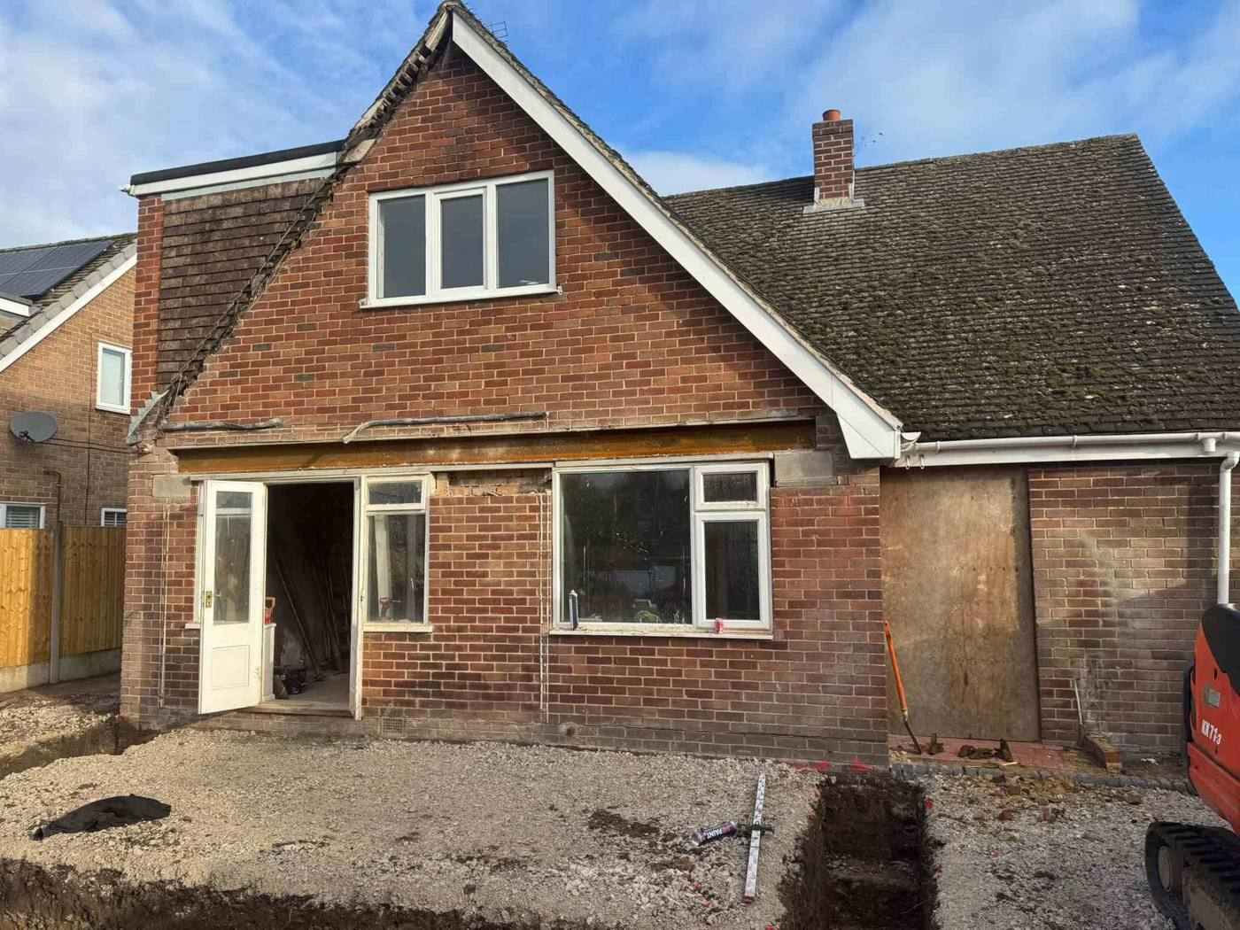 New steel beam installed across the back of a brick chalet bungalow by DOT Services, forming a wide opening for a rear extension